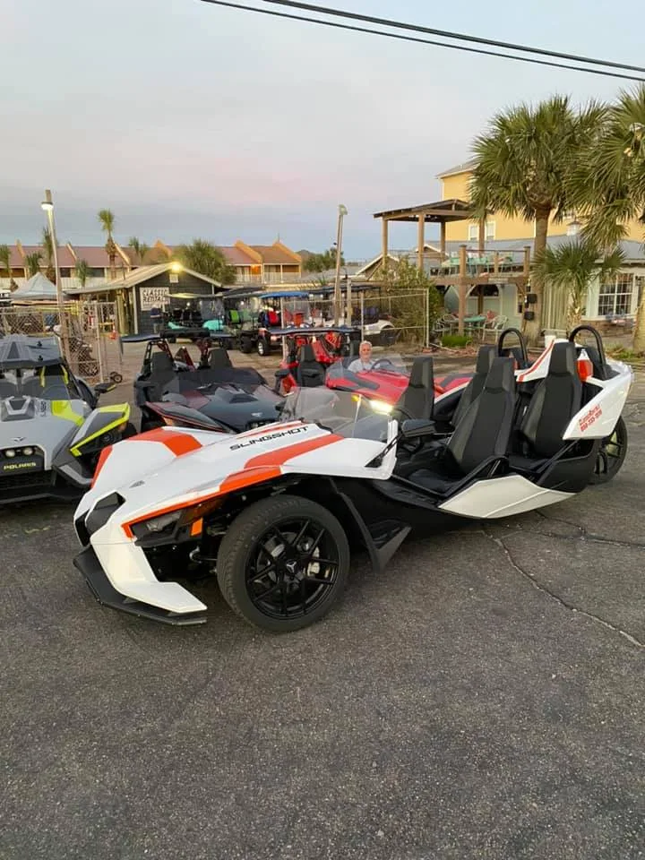 White and orange 4-seat Polaris Slingshot at the Classic Rentals lot