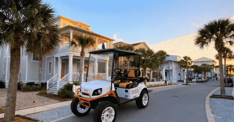 White lifted golf cart parked on a palm-lined street of beach houses at sunset